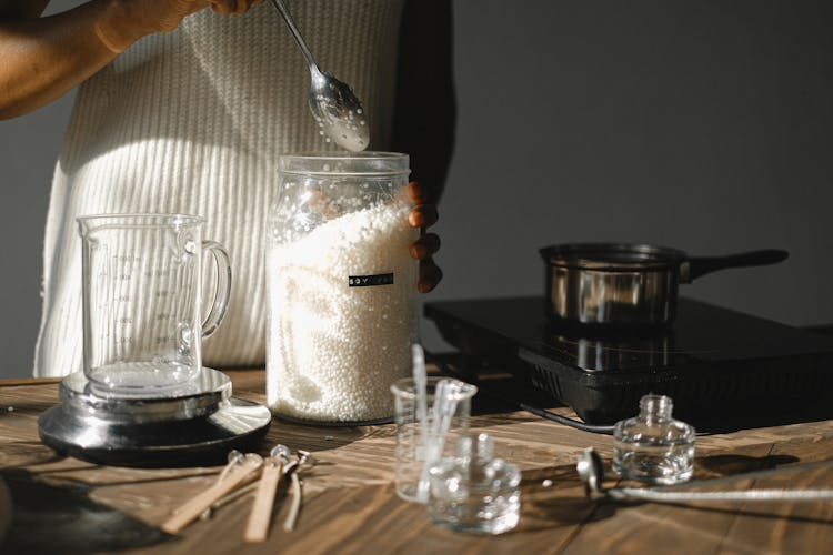 Crop Black Woman With Jar Of Wax Pellets