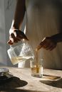 Black woman making candle with wooden wicks