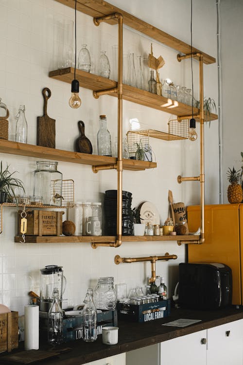 Free Interior of kitchen with different glass bottles and kitchenware placed on timber shelves Stock Photo