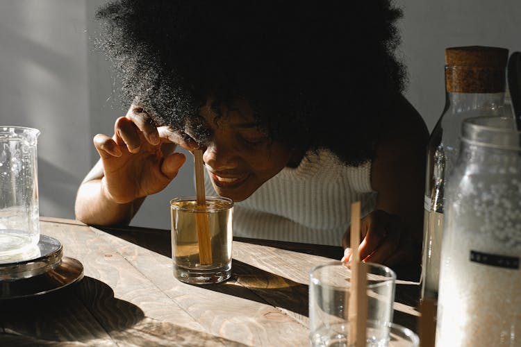 Woman Smelling A Liquid Mixture