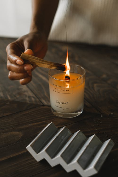 Crop black woman burning palo santo sticks at home