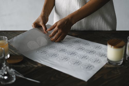 Crop black woman with stickers for handmade candles