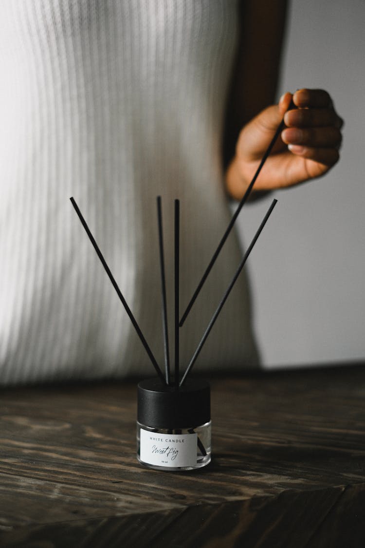 Crop Ethnic Woman With Incense Sticks And Essential Oil In Bottle