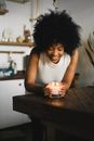 Ethnic woman with aromatic candle at home
