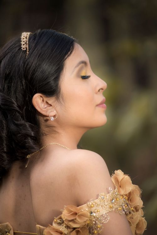 Free Graceful side profile shot of a young woman with closed eyes and tiara outdoors. Stock Photo