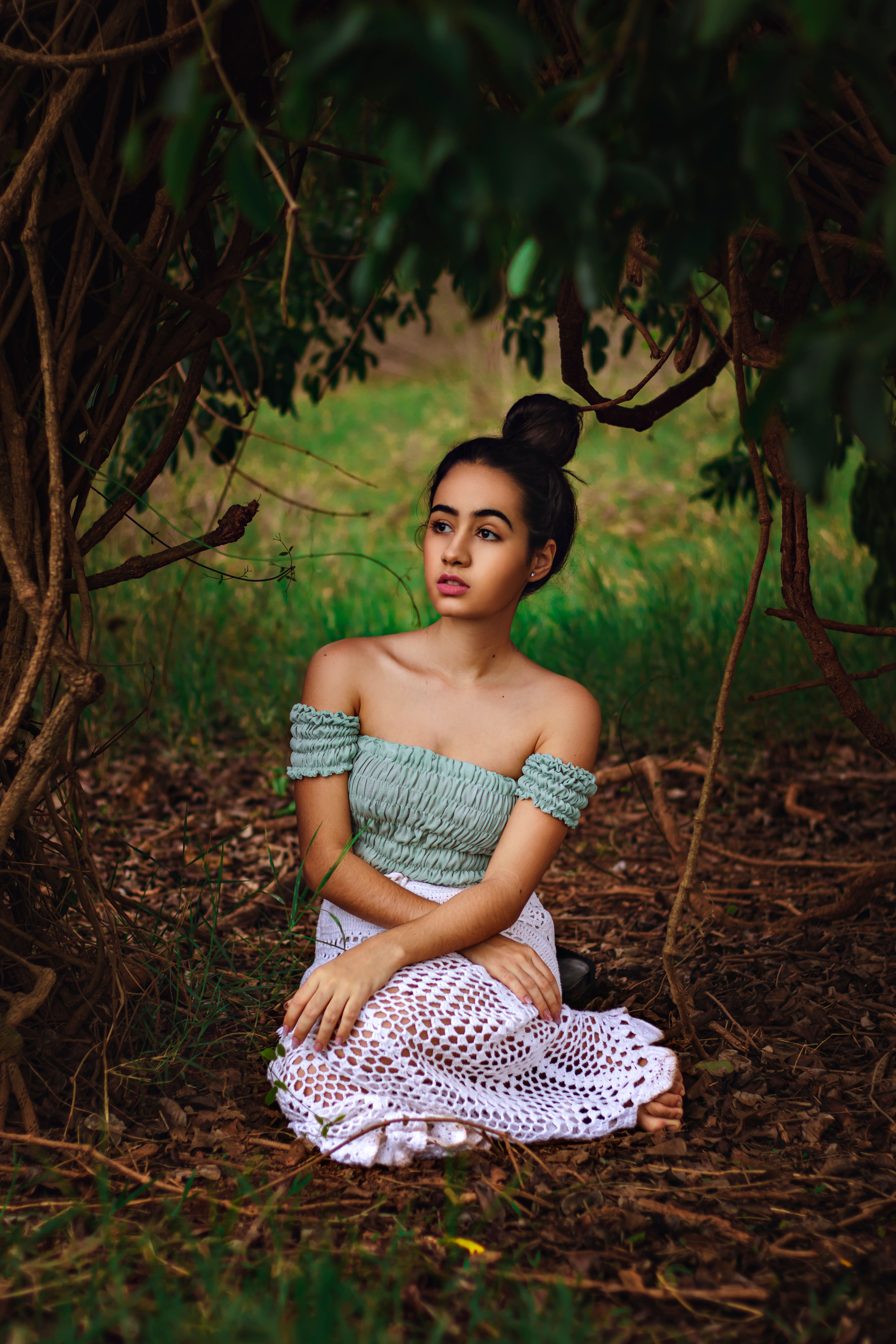Young Girl Sitting on a Tree Stump in a Forest · Free Stock Photo