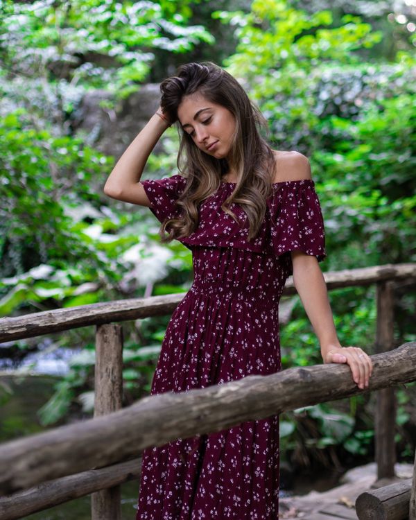 Woman wearing a deep red floral midi dress