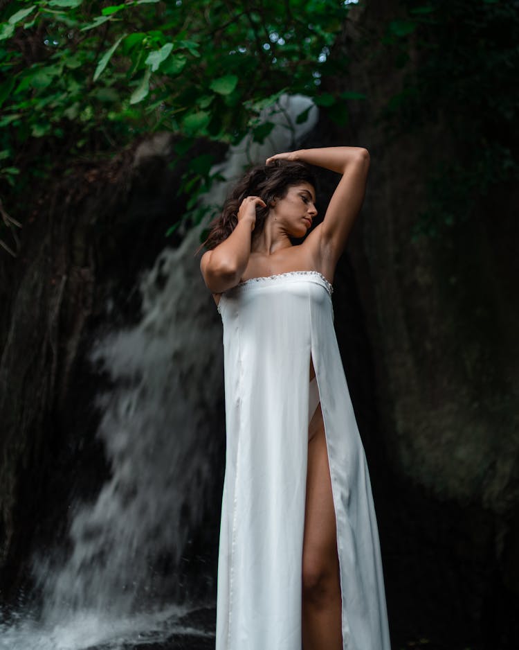 Gentle Woman Standing Near Waterfall In Park