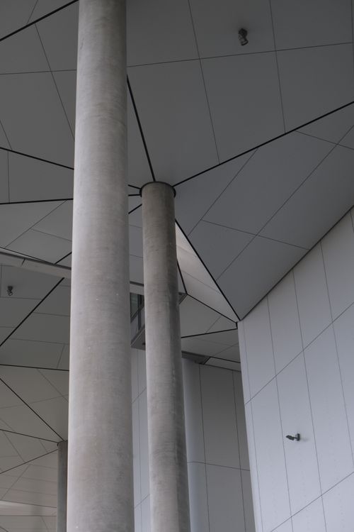 Free Abstract view of modern architecture showcasing columns and geometric ceiling design. Stock Photo