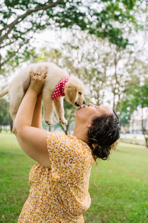 Photo Of a Puppy Licking The Woman's Face