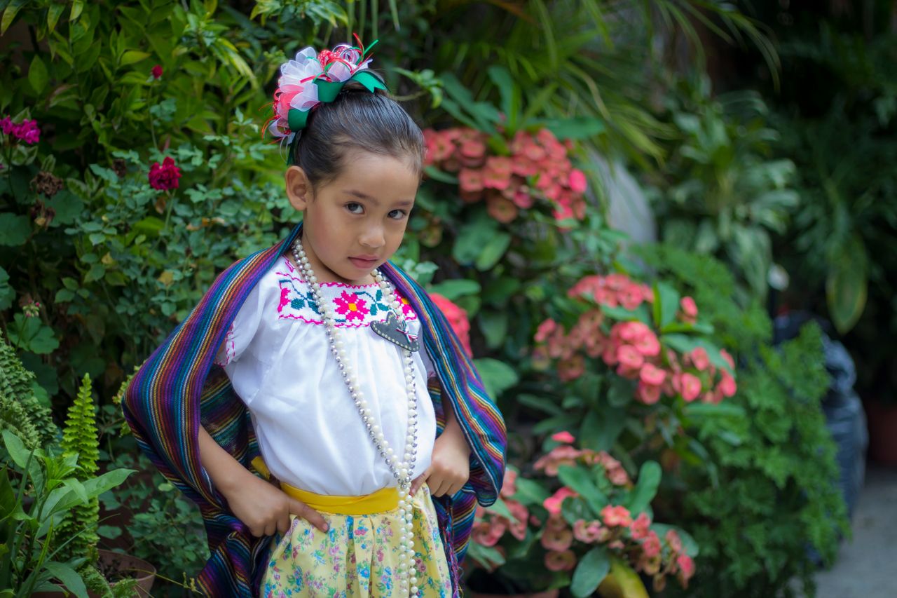 adorable young girl posing in colorful traditional attire with a vibra