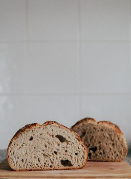 Delicious homemade bread cut on slices and placed on wooden board at kitchen