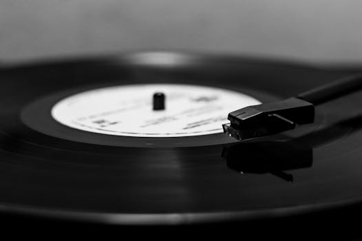 Black and white close-up of a vintage vinyl record spinning on a turntable, showcasing classic music nostalgia.