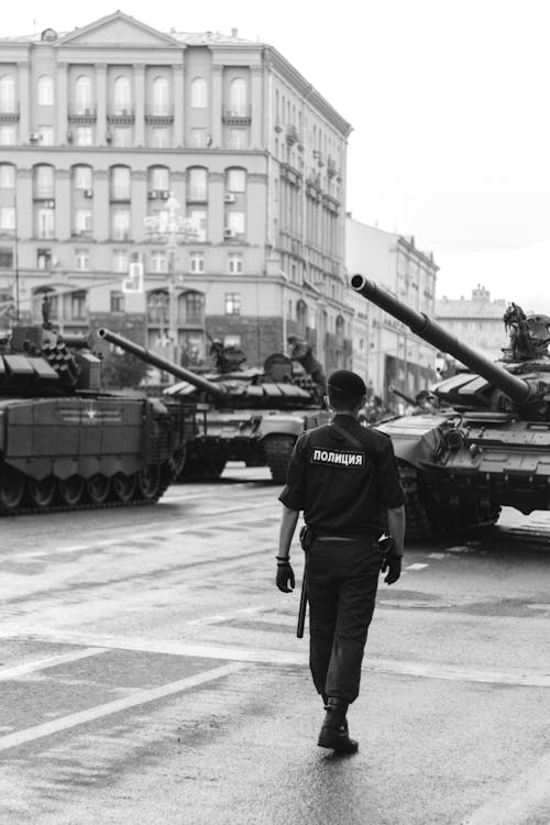 Policía Caminando Cerca De Tanques