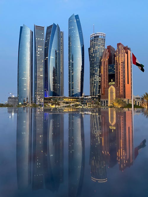 Free Modern city district in with tall skyscrapers places near calm water surface with reflection of environment located in Abu Dhabi Stock Photo