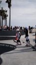 Full body of unrecognizable children wearing helmets and knee and elbows protectors standing with skateboards near ramp in skate park