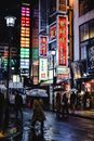 雨夜，日本街头充满活力，人们打着伞行走