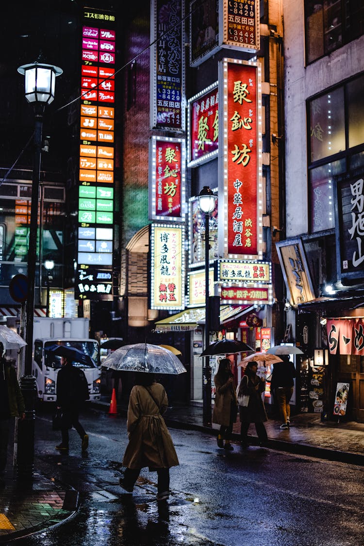 People Walking On Street Carrying Umbrella