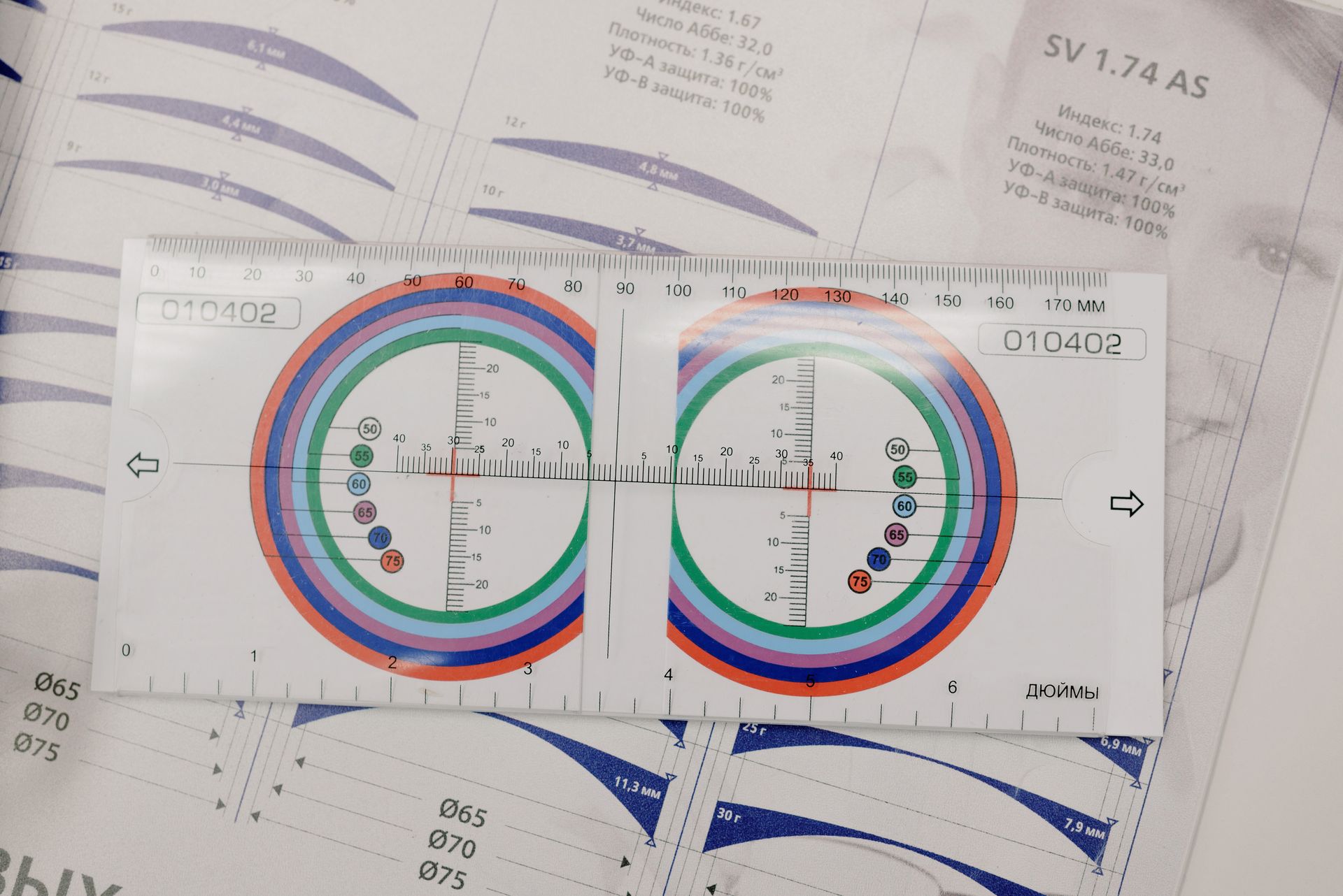 From above of manual optical tool with numbers and arrows on paper with brochure on table