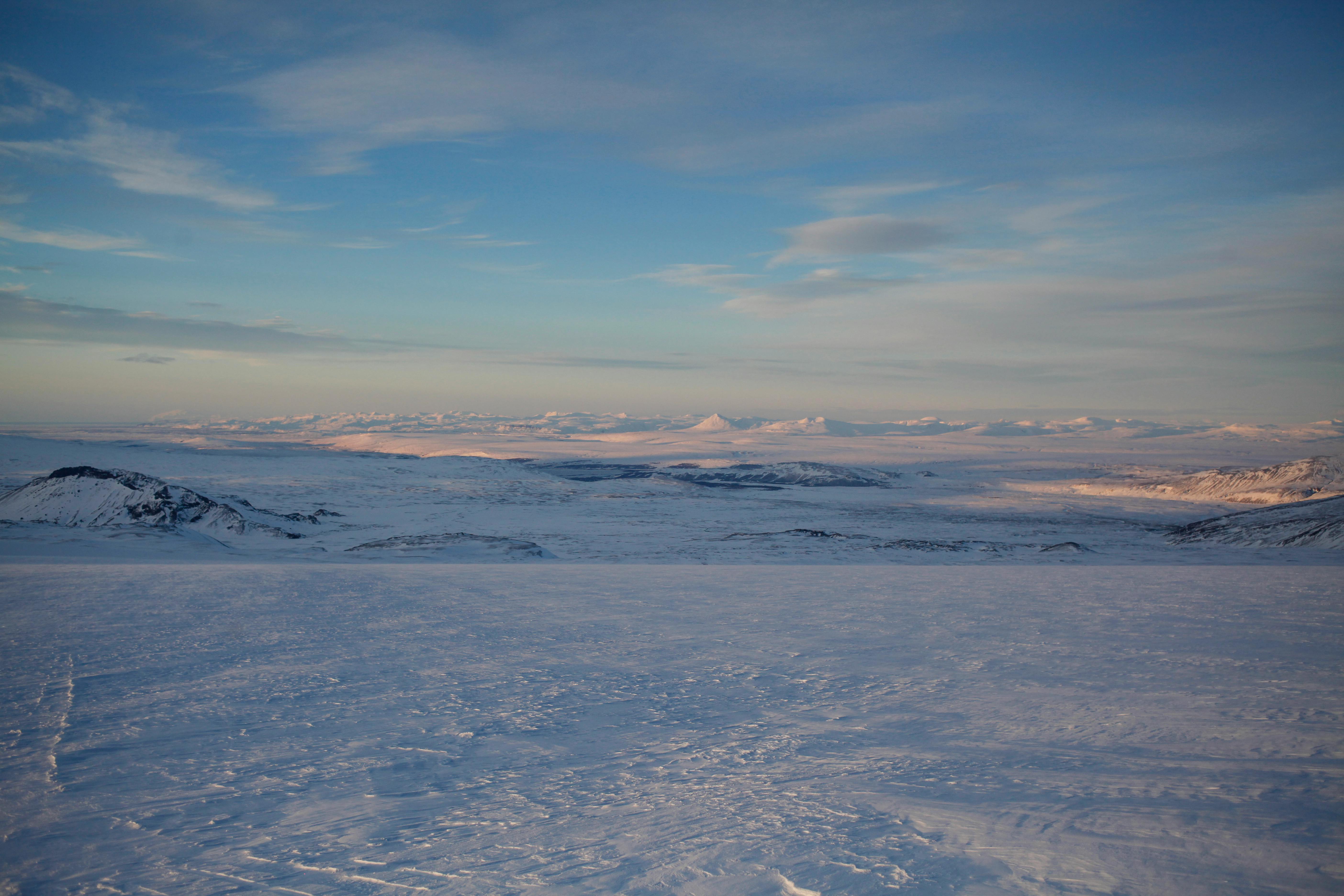 Expansive view of Iceland's snow-covered Langjökull Glacier under a serene winter sky.