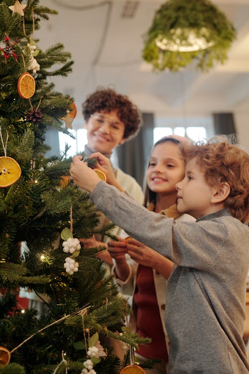 Free Family Decorating a Christmas Tree Stock Photo