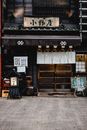 传统日本居酒屋的入口处，装饰着木制招牌和其他装饰元素
