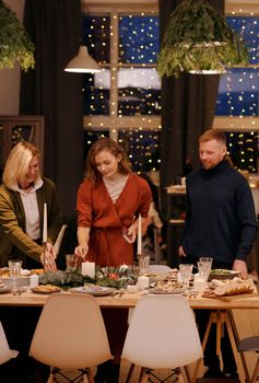 A joyful holiday dinner setting with friends and family gathering indoors.