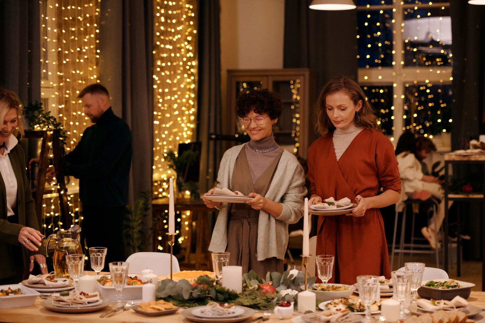 Two women arranging a Christmas dinner table together.