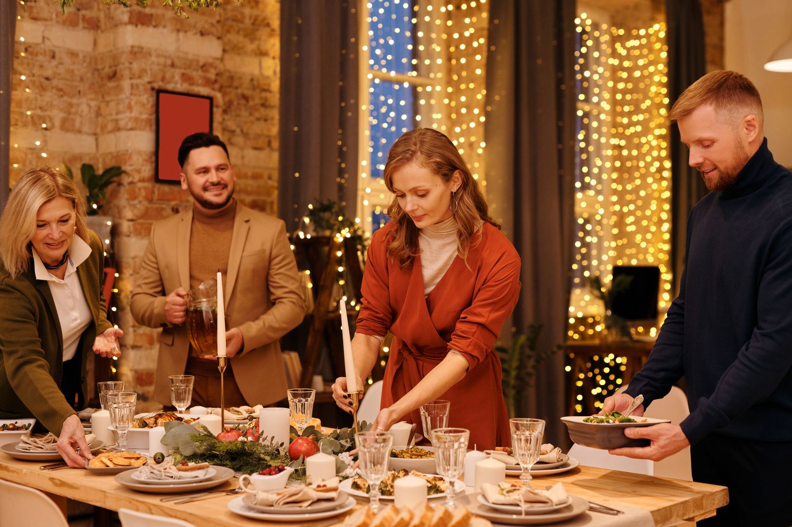 Family arranging place settings and dishes for Christmas dinner.