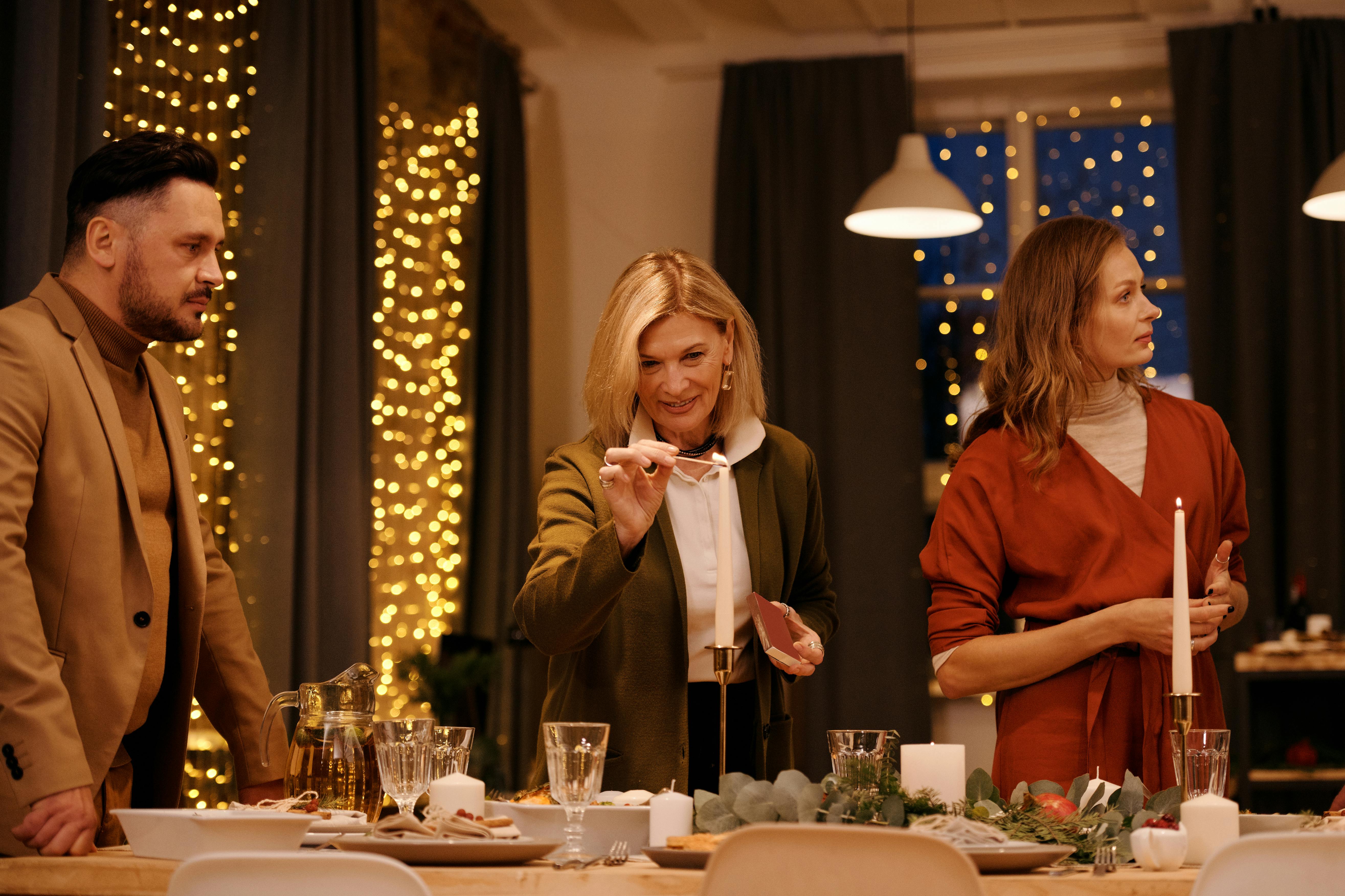 Family gathered for a warm candlelit dinner during Christmas season indoors.
