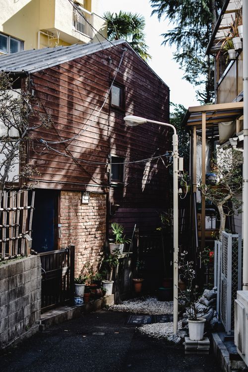 Free Discover a quaint alleyway surrounded by traditional wooden and brick buildings in Tokyo, Japan. Stock Photo