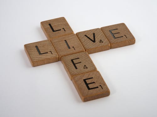 Close-Up Shot of Scrabble Tiles on a White Surface