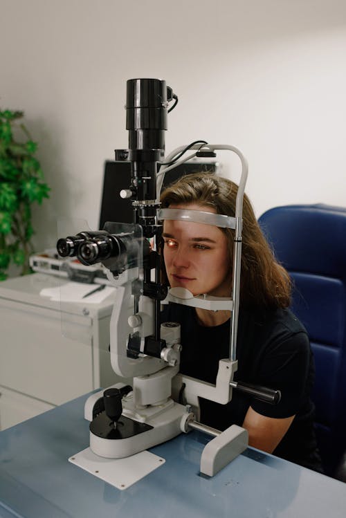 Free Woman testing vision on modern equipment in ophthalmology clinic Stock Photo