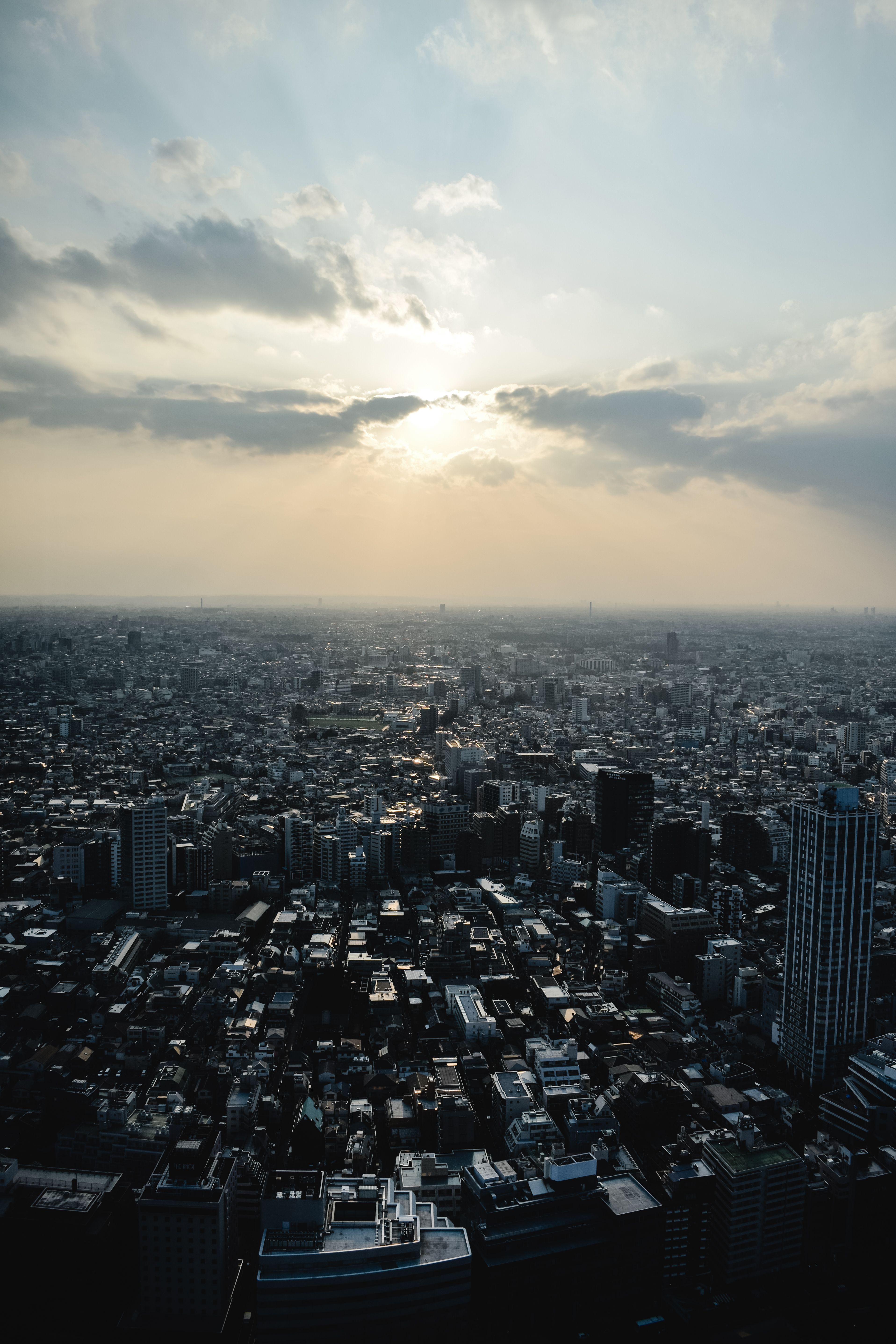 从空中俯瞰，东京的城市景观令人惊叹，戏剧性的日落照亮了整座城市