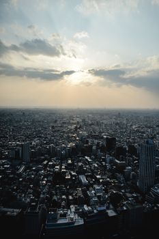 从空中俯瞰，东京的城市景观令人惊叹，戏剧性的日落照亮了整座城市