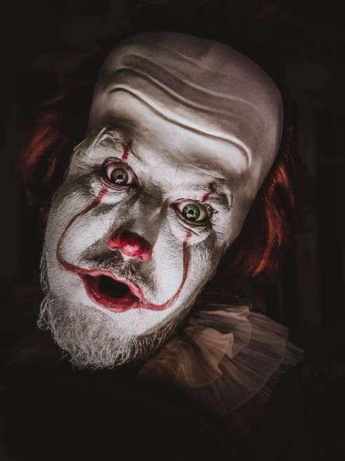 Free Close-up of a scary clown with detailed Halloween makeup, creating a spooky and eerie atmosphere. Stock Photo