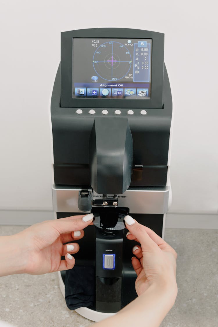 Doctor Checking Lens On Machine In Hospital