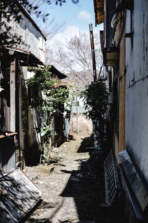 Free A tranquil alleyway between traditional wooden houses in Nikko, Japan, offering rustic charm. Stock Photo