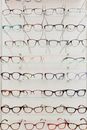 Stylish rims with lenses for vision arranged on glass shelves in ophthalmology salon