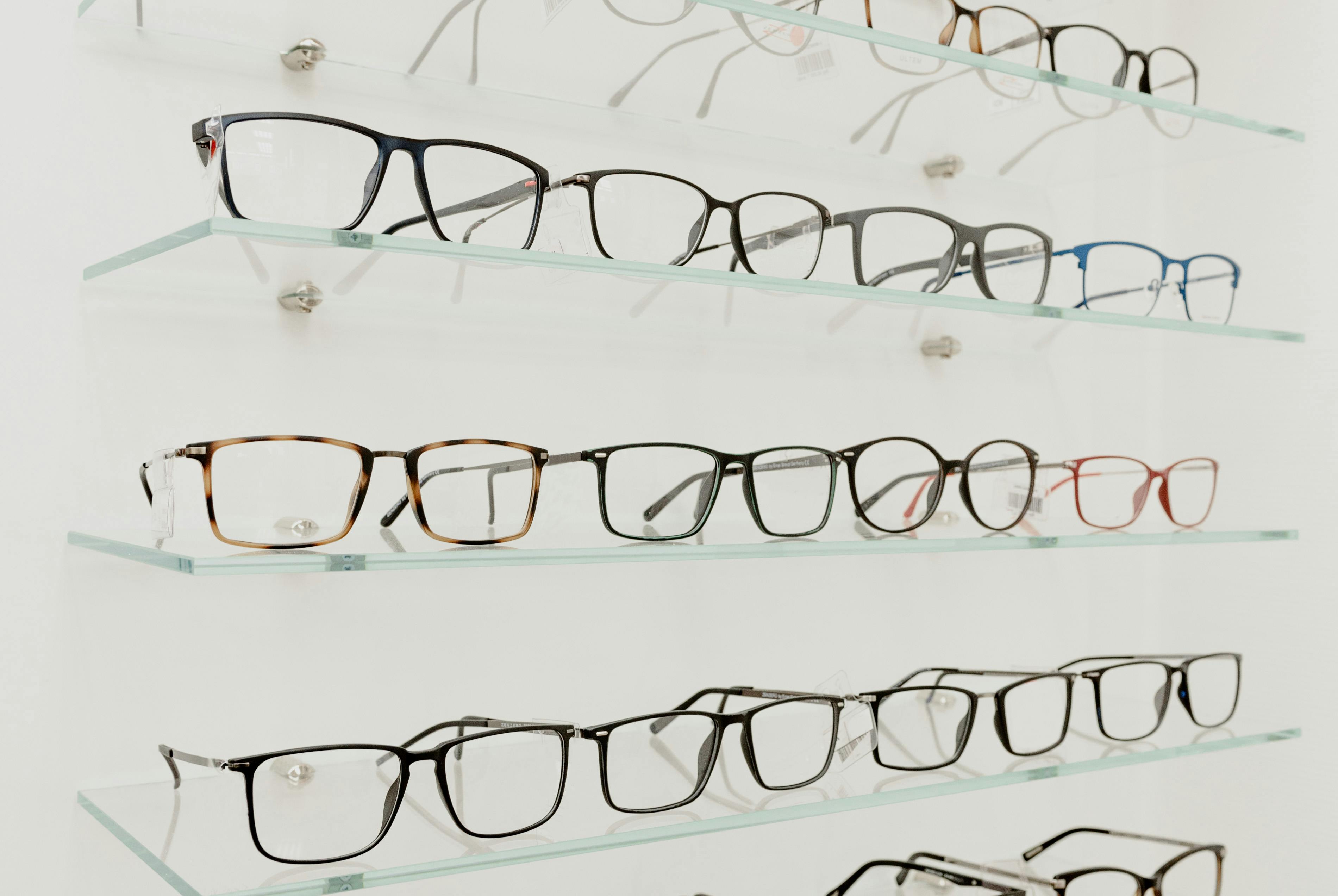 collection of eyeglasses on shelves in store