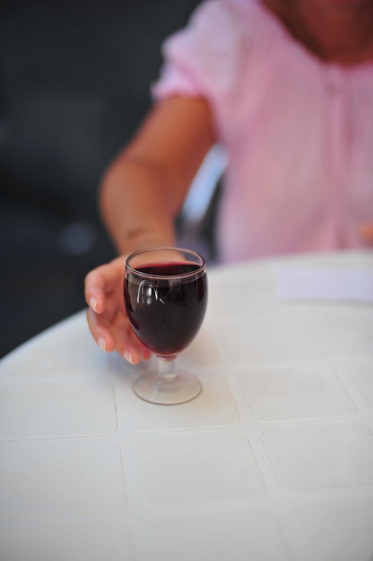 Woman Reaching For A Glass Of Red Wine 