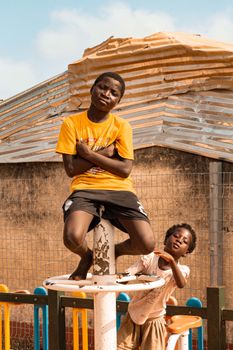 Two children enjoying an outdoor playground on a sunny day, showcasing fun and leisure.