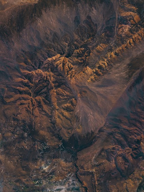 Free Amazing aerial view of sandy volcanic terrain with rocky mountains on sunny day Stock Photo