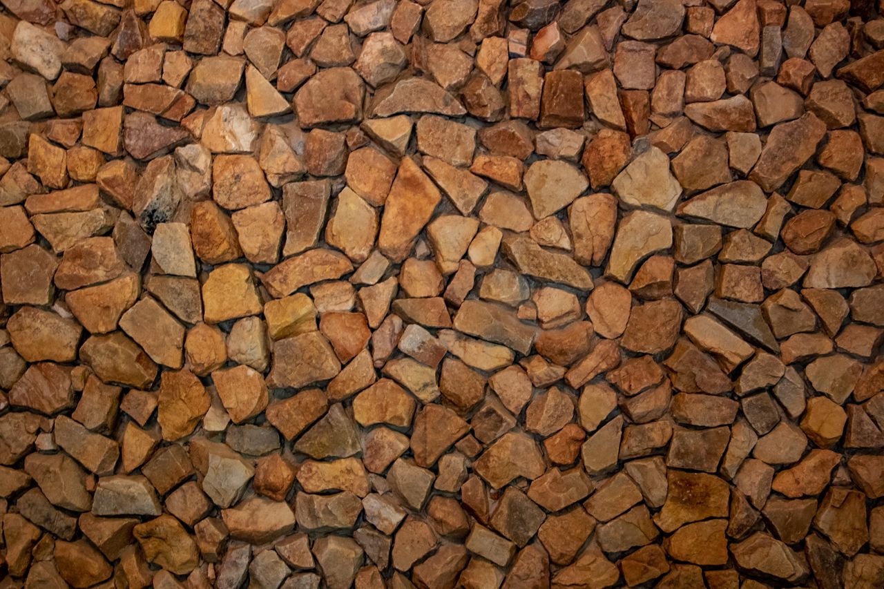 high resolution image of a natural stone wall with various brown hues
