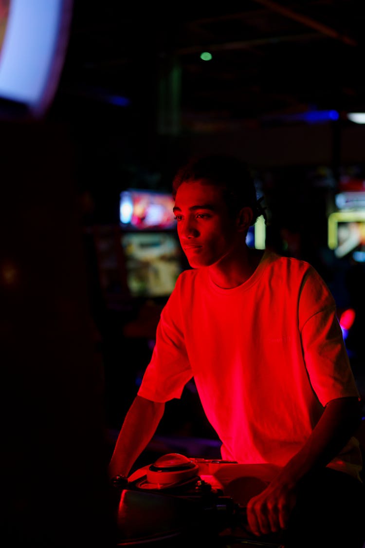 A Man Playing In An Arcade