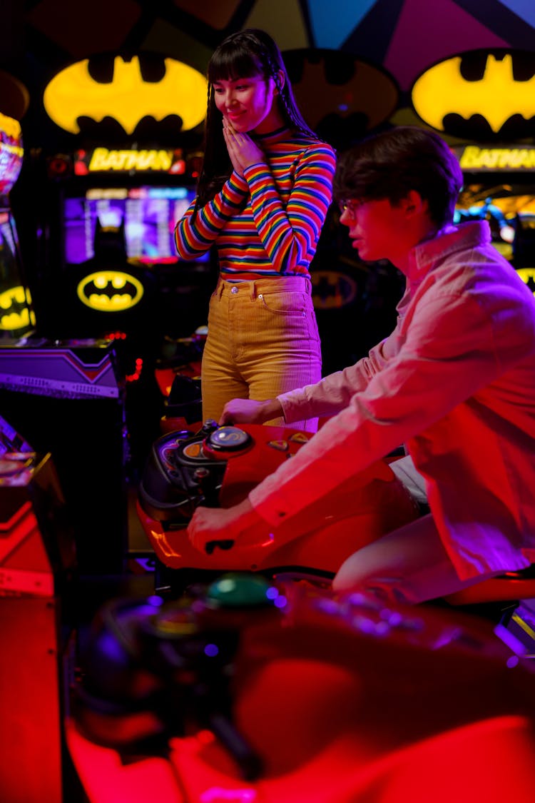 A Woman Cheering A Man Riding A Motorcycle Arcade Game