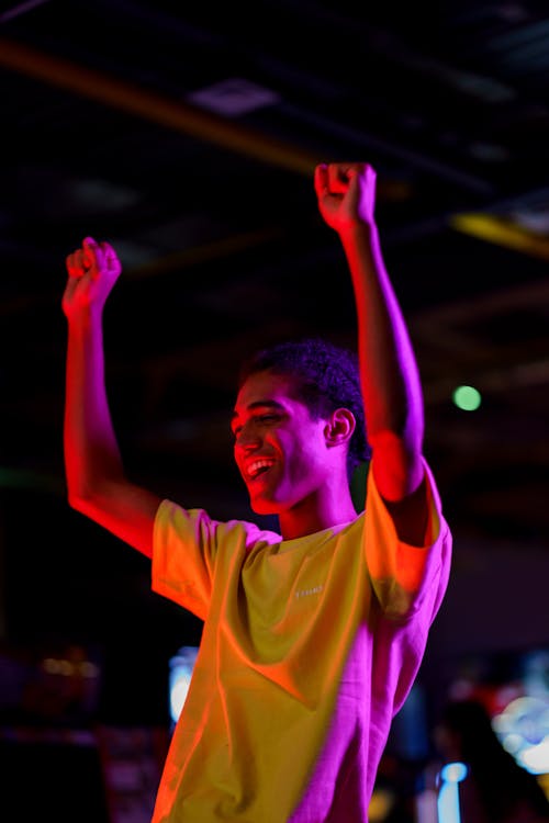 Happy Man in Yellow Crew Neck T-shirt Raising his Hands 