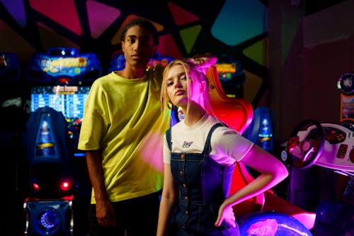 Young Couple Inside an Amusement Arcade Park Seriously Looking at the Camera