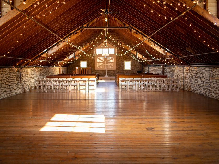 Beamed interior strung with lights, set for a ceremony