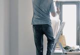 Handyman on a ladder doing renovation work indoors